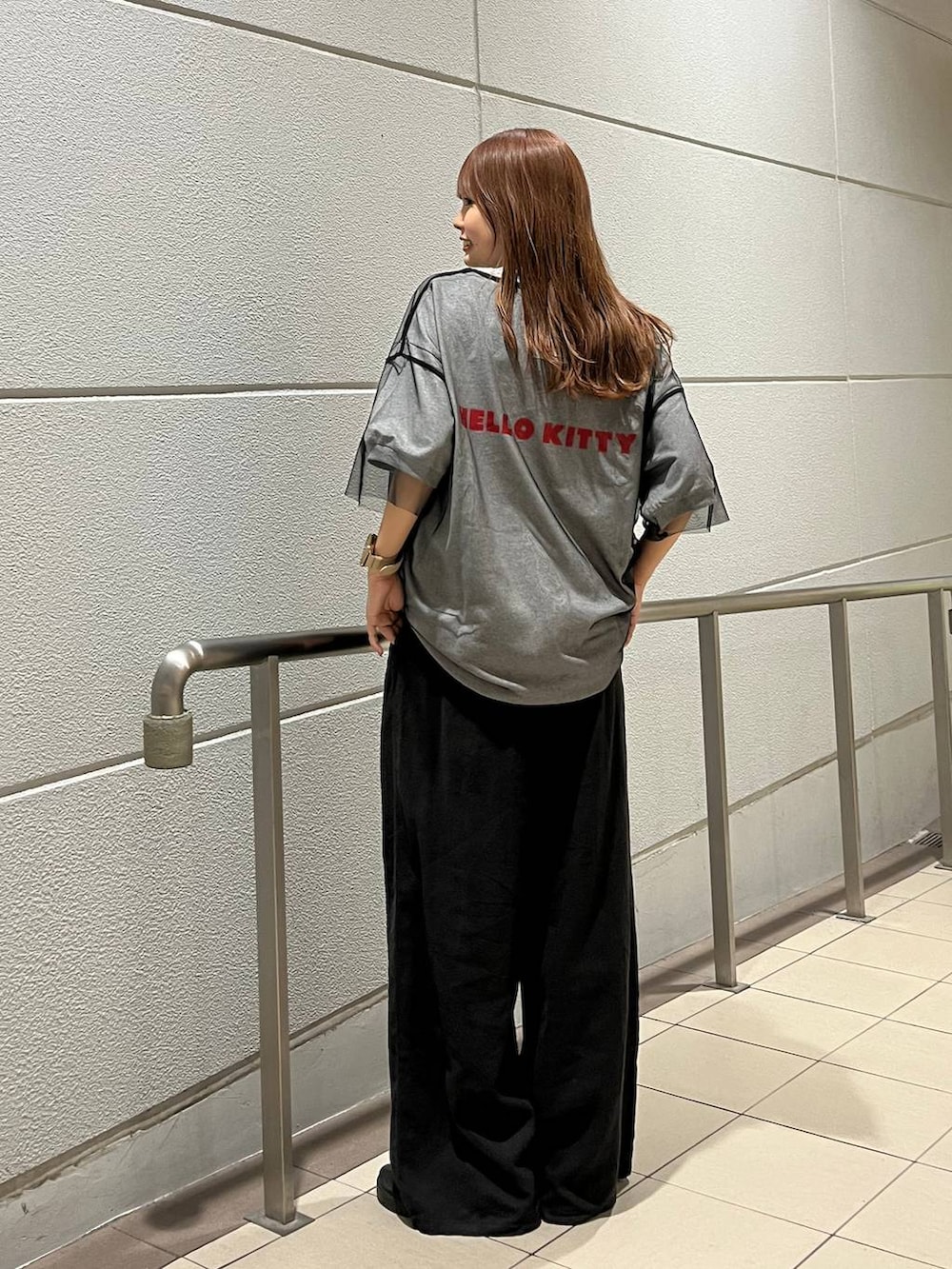 ブラック系のTシャツ/カットソー、ブラック系のスニーカー、グレー系のスラックスを着用したレディースの夏コーディネートの4枚目の写真