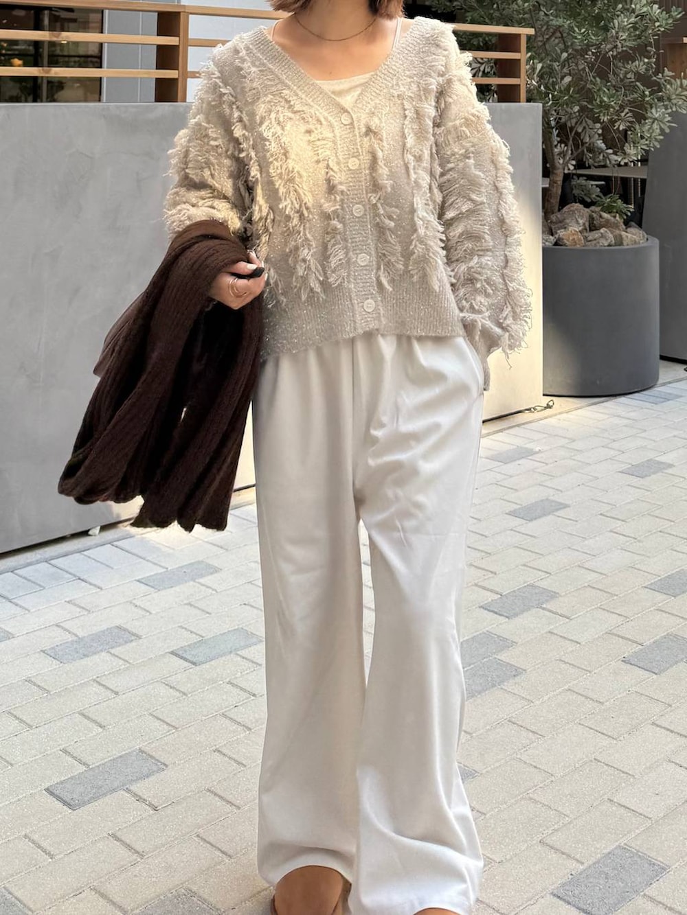 ホワイト系のその他パンツ、ホワイト系のキャミソール、ベージュ系のブーツを着用したレディースの秋コーディネートの3枚目の写真