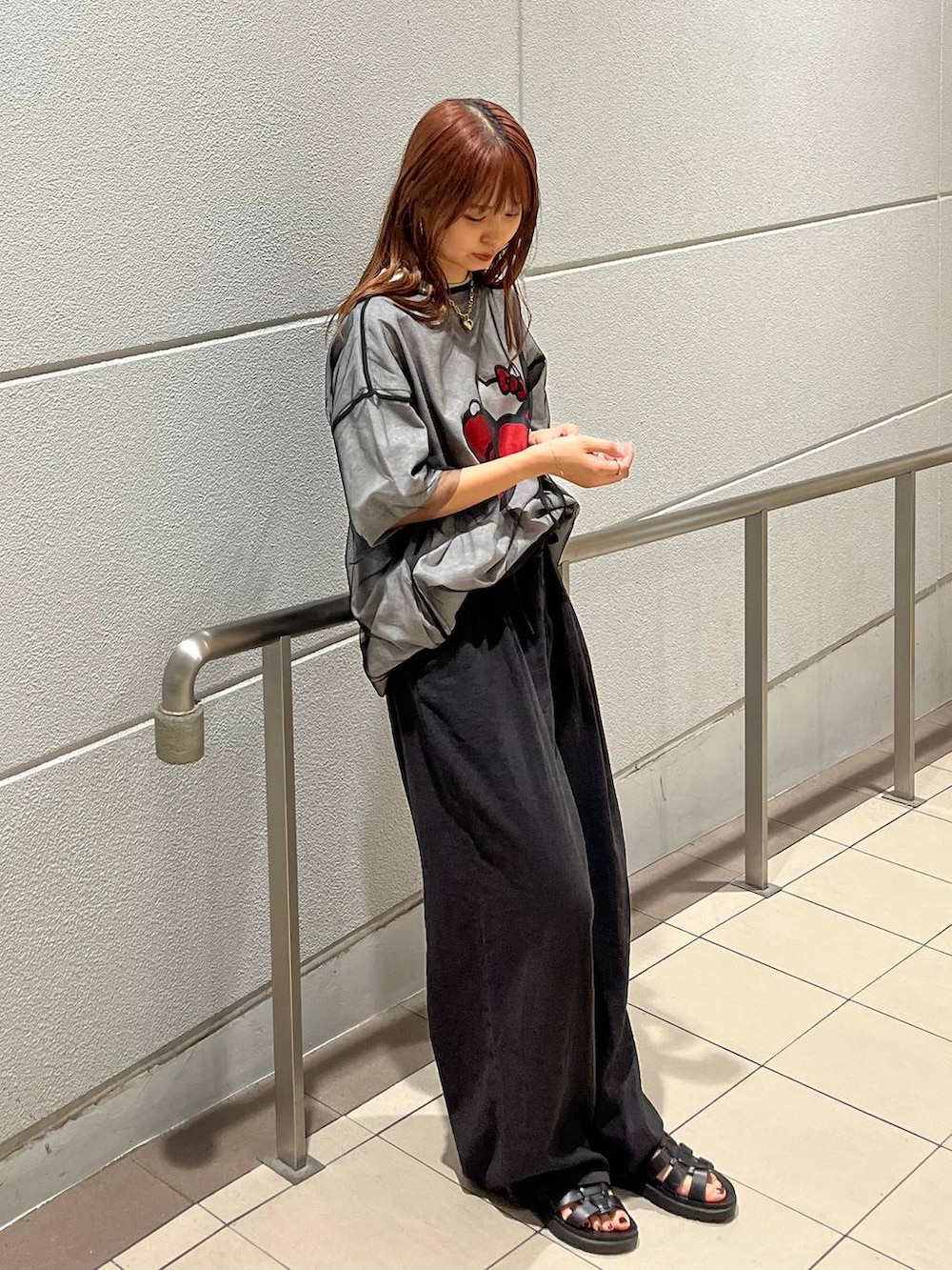 ブラック系のTシャツ/カットソー、ブラック系のスニーカー、グレー系のスラックスを着用したレディースの夏コーディネートの2枚目の写真