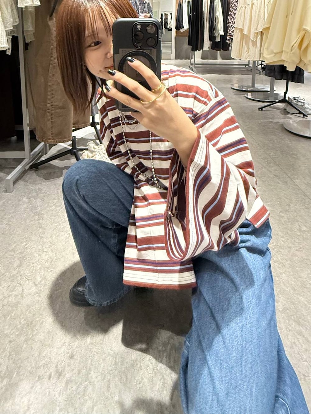 ブルー系のデニムパンツ、ブラック系のローファー、ホワイト系のTシャツ/カットソーを着用したレディースの秋コーディネートの6枚目の写真