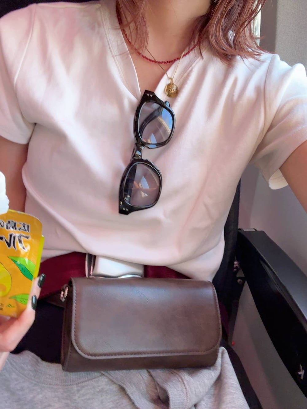 ホワイト系のTシャツ/カットソー、ブラウン系のボディバッグ/ウエストポーチ、その他のサングラスを着用したレディースの春コーディネートの3枚目の写真