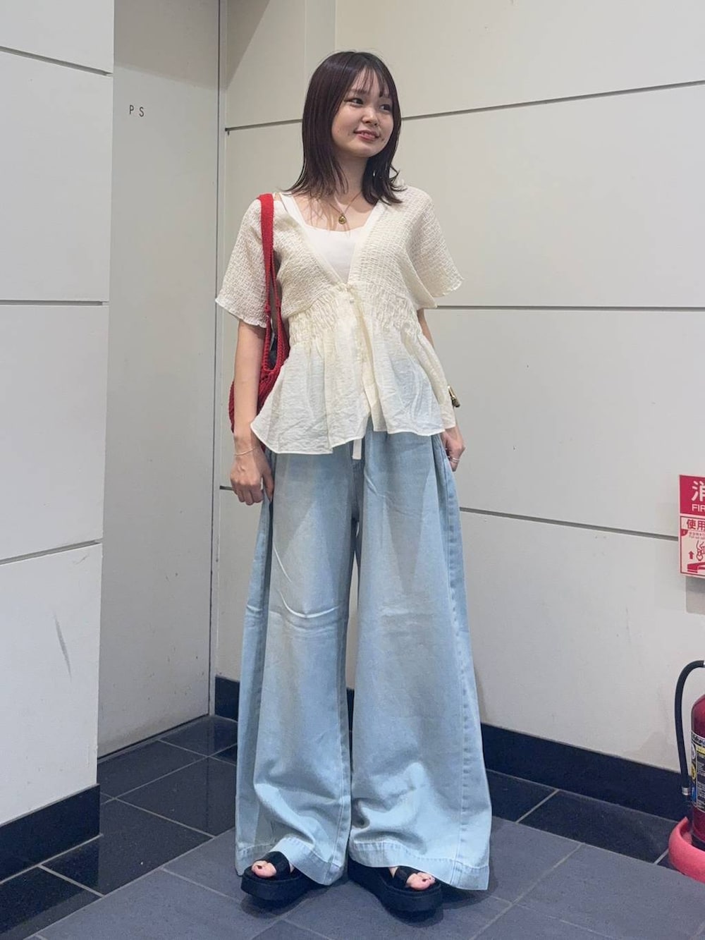ブラック系のサンダル、ホワイト系のシャツ/ブラウス、ブルー系のデニムパンツを着用したレディースの夏コーディネートの4枚目の写真
