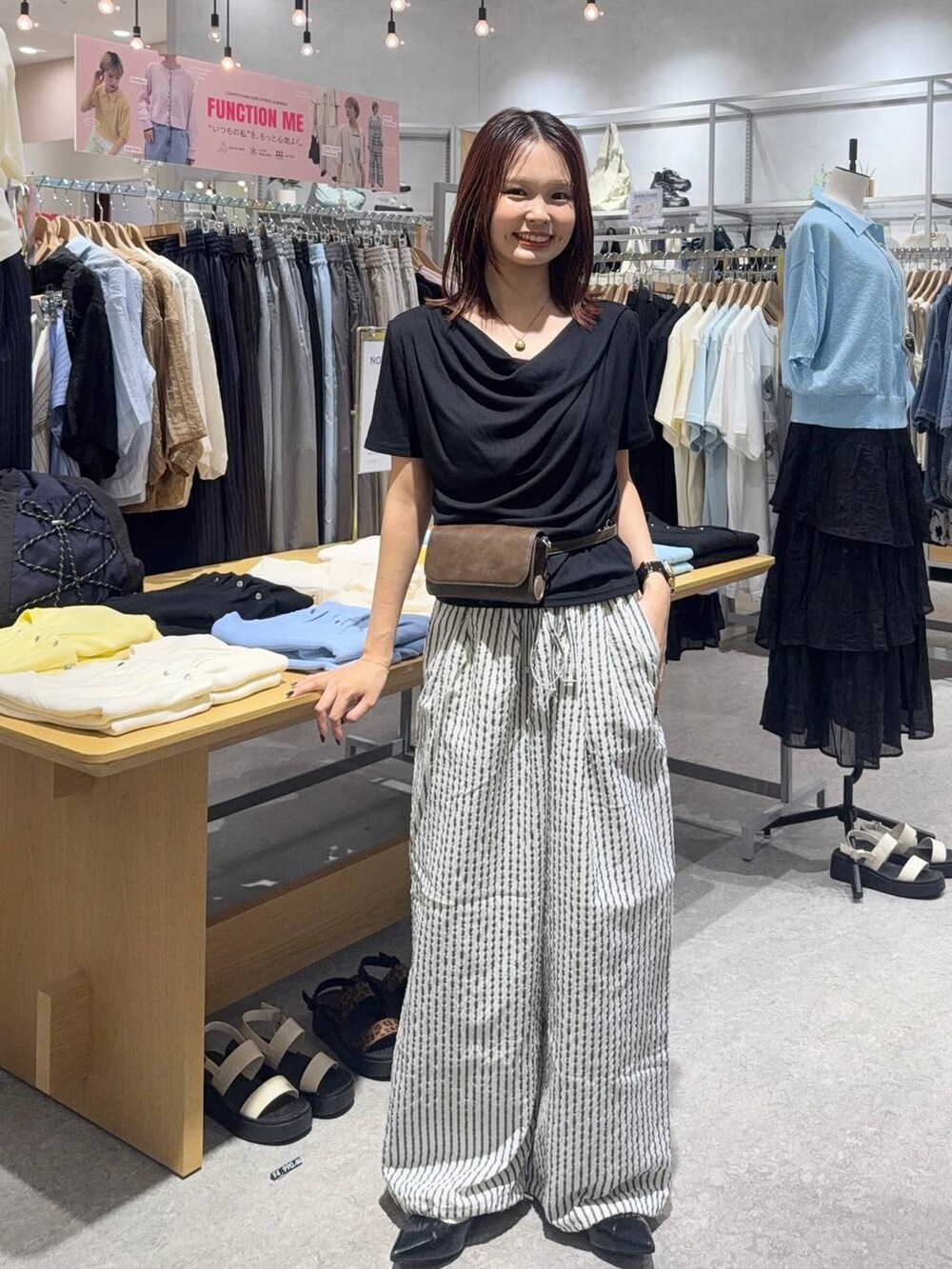 ブラック系のパンプス、ブラック系のTシャツ/カットソー、ブラウン系のボディバッグ/ウエストポーチを着用したレディースの春コーディネートの3枚目の写真