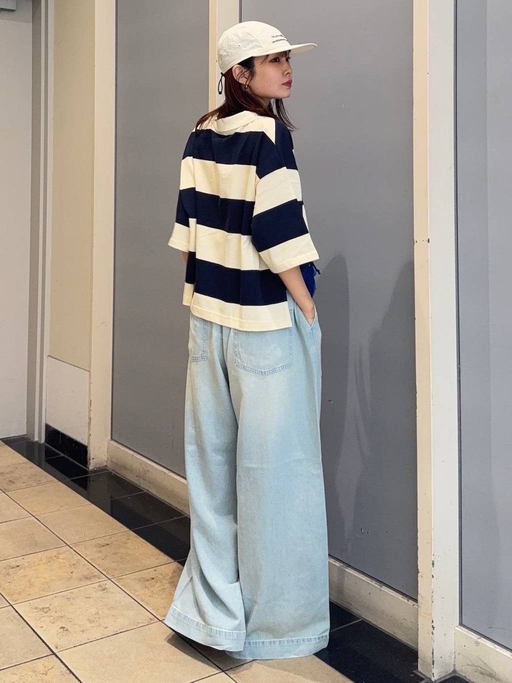 ブラック系のサンダル、ブルー系のデニムパンツ、ブルー系のTシャツ/カットソーを着用したレディースの夏コーディネートの2枚目の写真