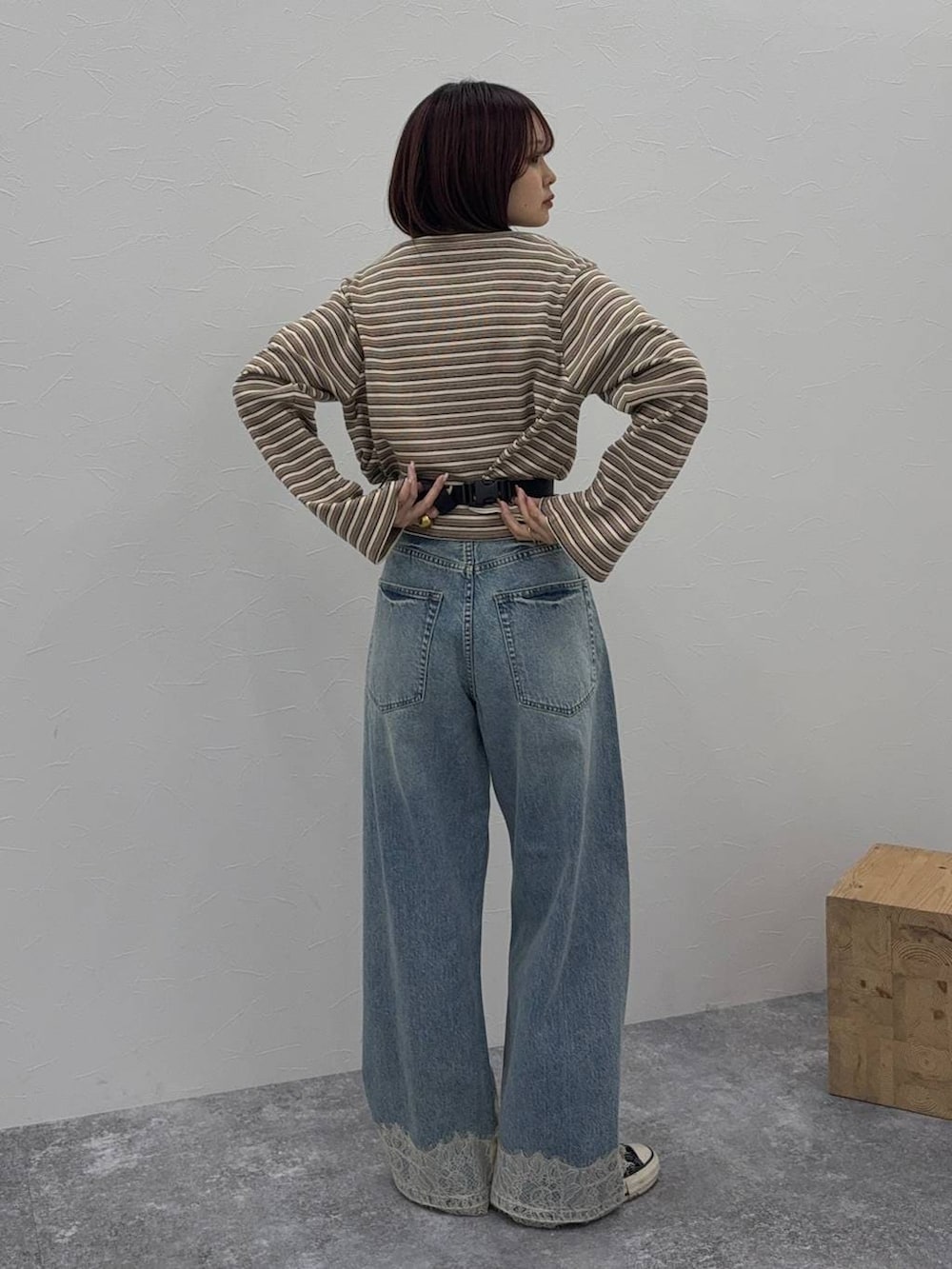 ブルー系のデニムパンツ、ブラック系のボディバッグ/ウエストポーチ、ベージュ系のカーディガン/ボレロを着用したレディースの冬コーディネートの3枚目の写真