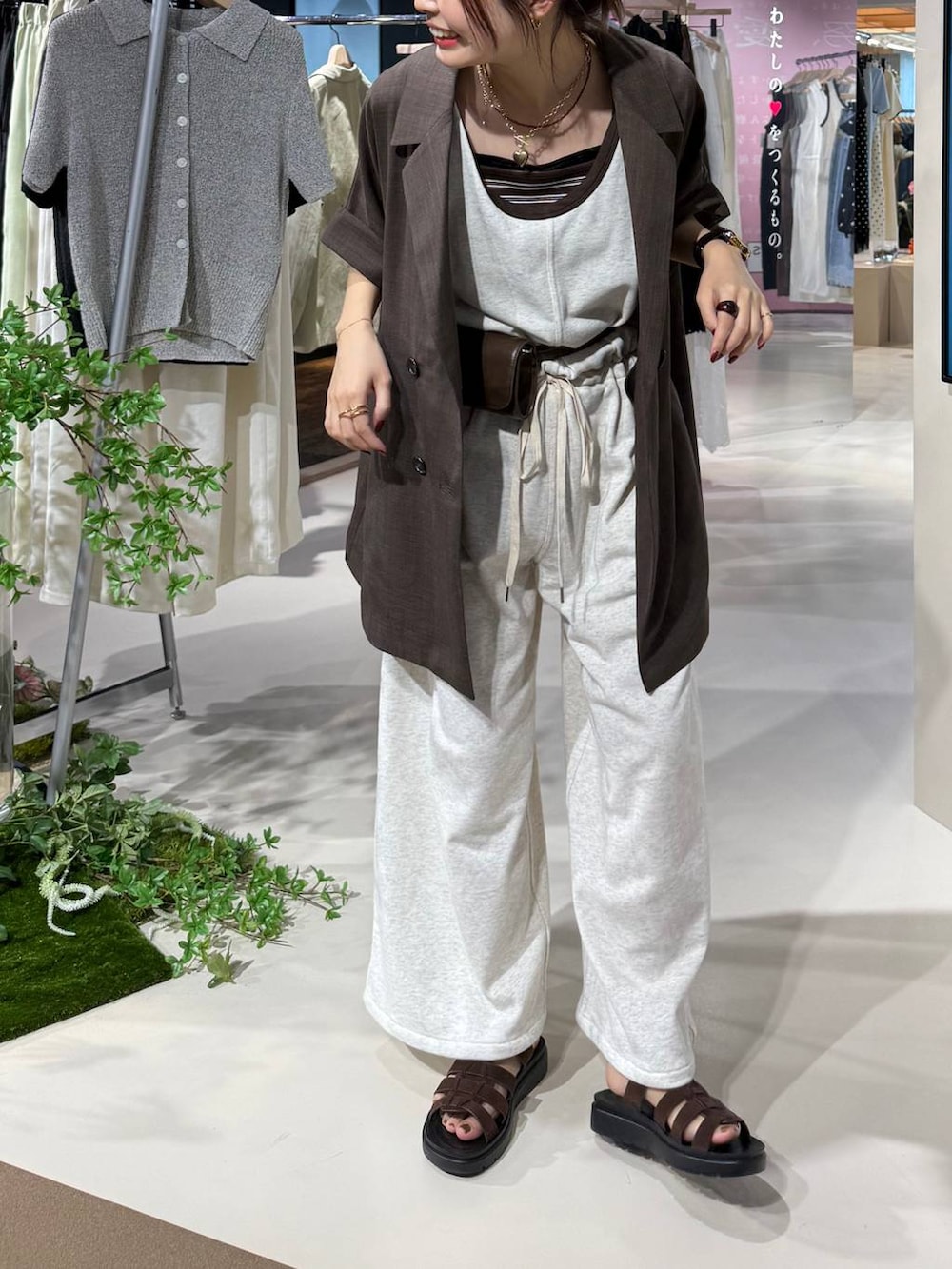 ブラウン系のテーラードジャケット、ブラウン系のサンダル、ブラウン系のタンクトップを着用したレディースの春コーディネートの2枚目の写真