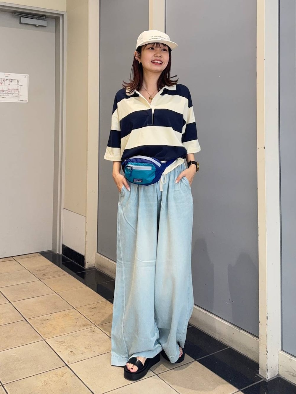 ブラック系のサンダル、ブルー系のデニムパンツ、ブルー系のTシャツ/カットソーを着用したレディースの夏コーディネートの8枚目の写真