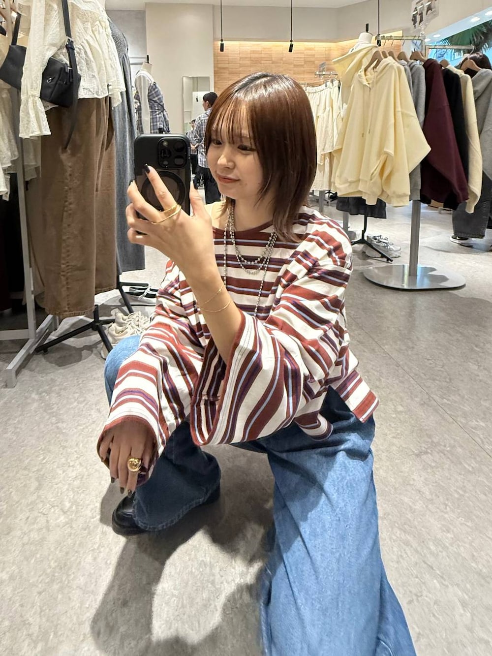 ブルー系のデニムパンツ、ブラック系のローファー、ホワイト系のTシャツ/カットソーを着用したレディースの秋コーディネートの4枚目の写真