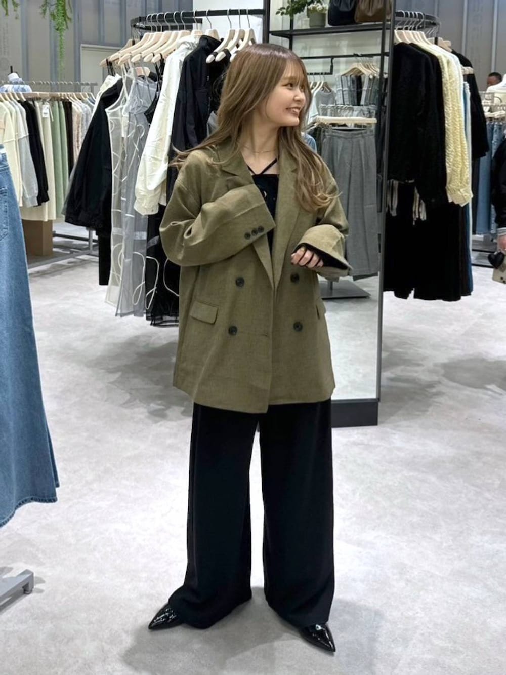 ブラック系のニット/セーター、ブラウン系のテーラードジャケット、ブラック系のその他パンツを着用したレディースの春コーディネートの4枚目の写真