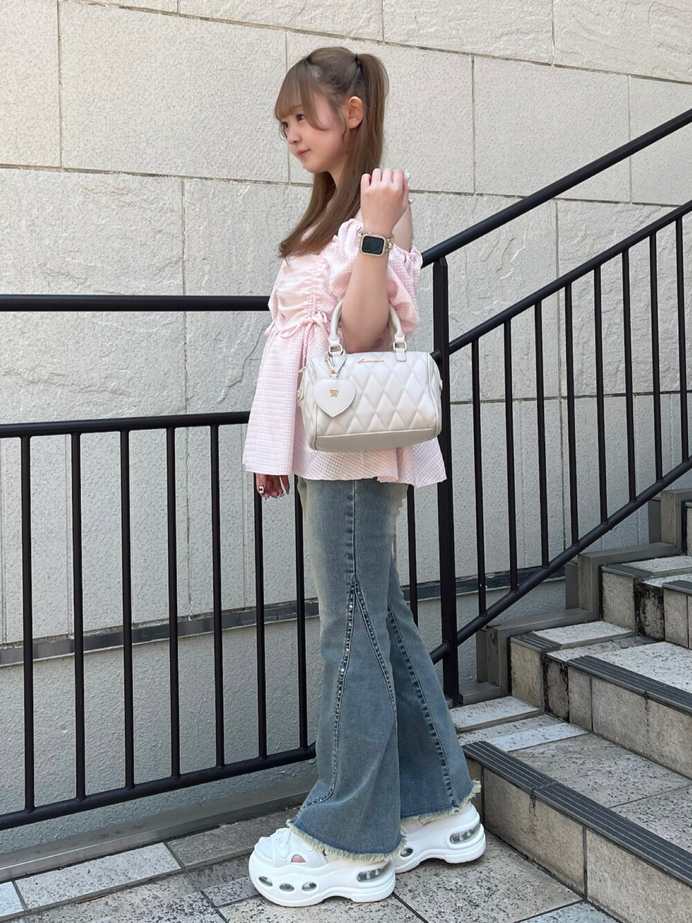 ピンク系のシャツ/ブラウス、ベージュ系のボストンバッグ、ブルー系のデニムパンツを着用したレディースの夏コーディネートの2枚目の写真