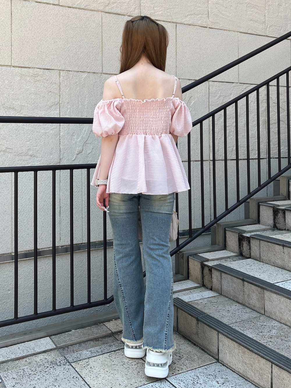 ピンク系のシャツ/ブラウス、ベージュ系のボストンバッグ、ブルー系のデニムパンツを着用したレディースの夏コーディネートの3枚目の写真