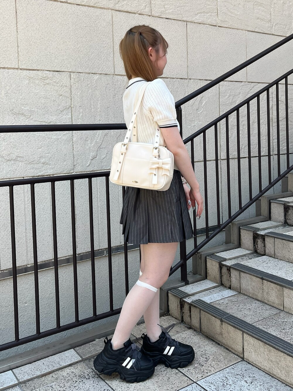 ホワイト系のポロシャツ、その他のスカート、ホワイト系のショルダーバッグを着用したレディースの夏コーディネートの2枚目の写真