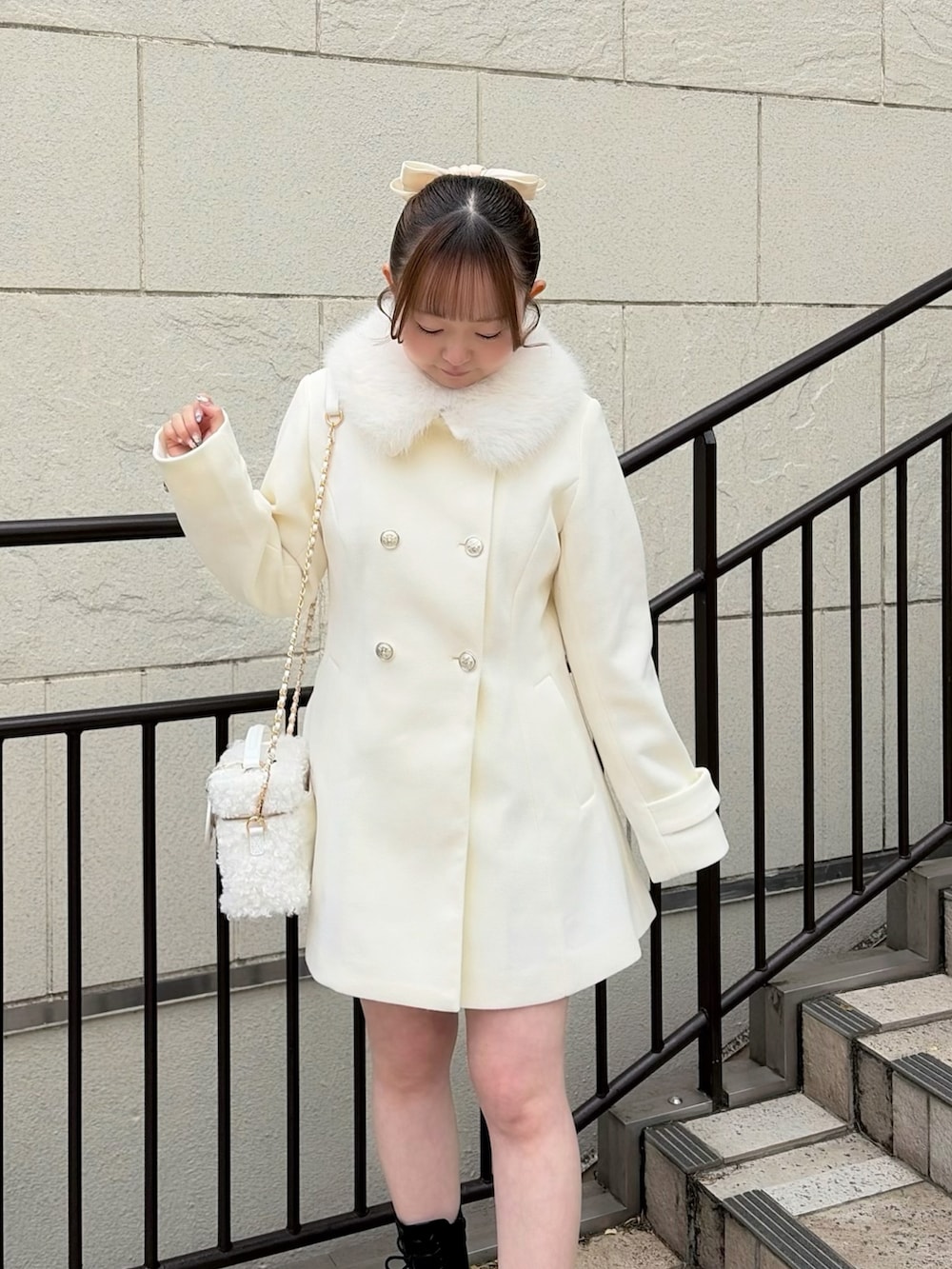 ホワイト系のステンカラーコート、ホワイト系のショルダーバッグ、ブラック系のブーツを着用したレディースの冬コーディネートの4枚目の写真