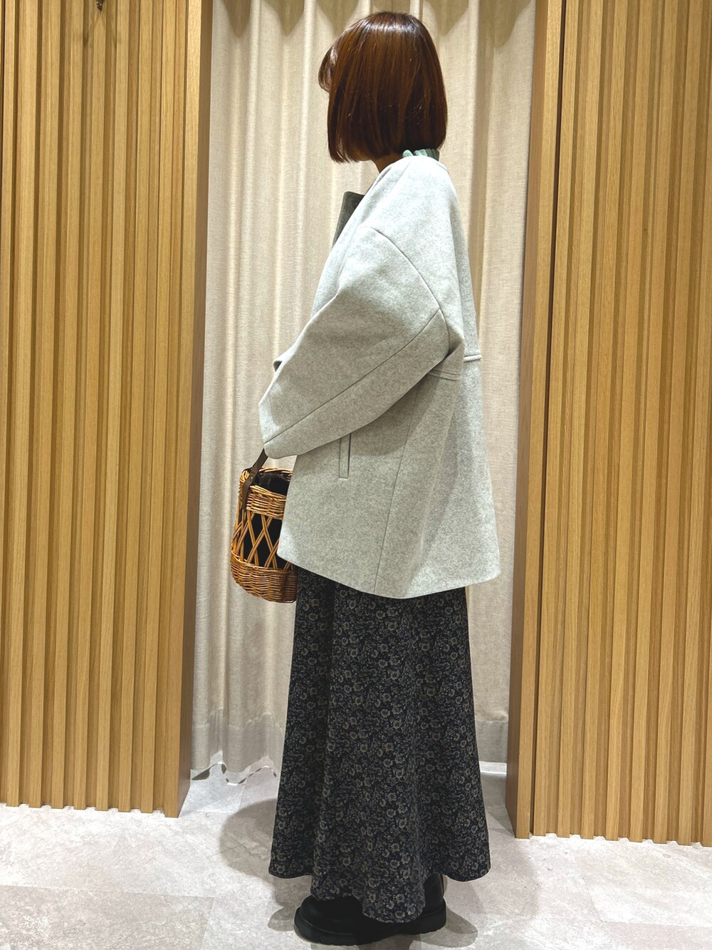 グリーン系のニット/セーター、グレー系のその他アウター、ブラック系のスカートを着用したレディースの秋コーディネートの3枚目の写真