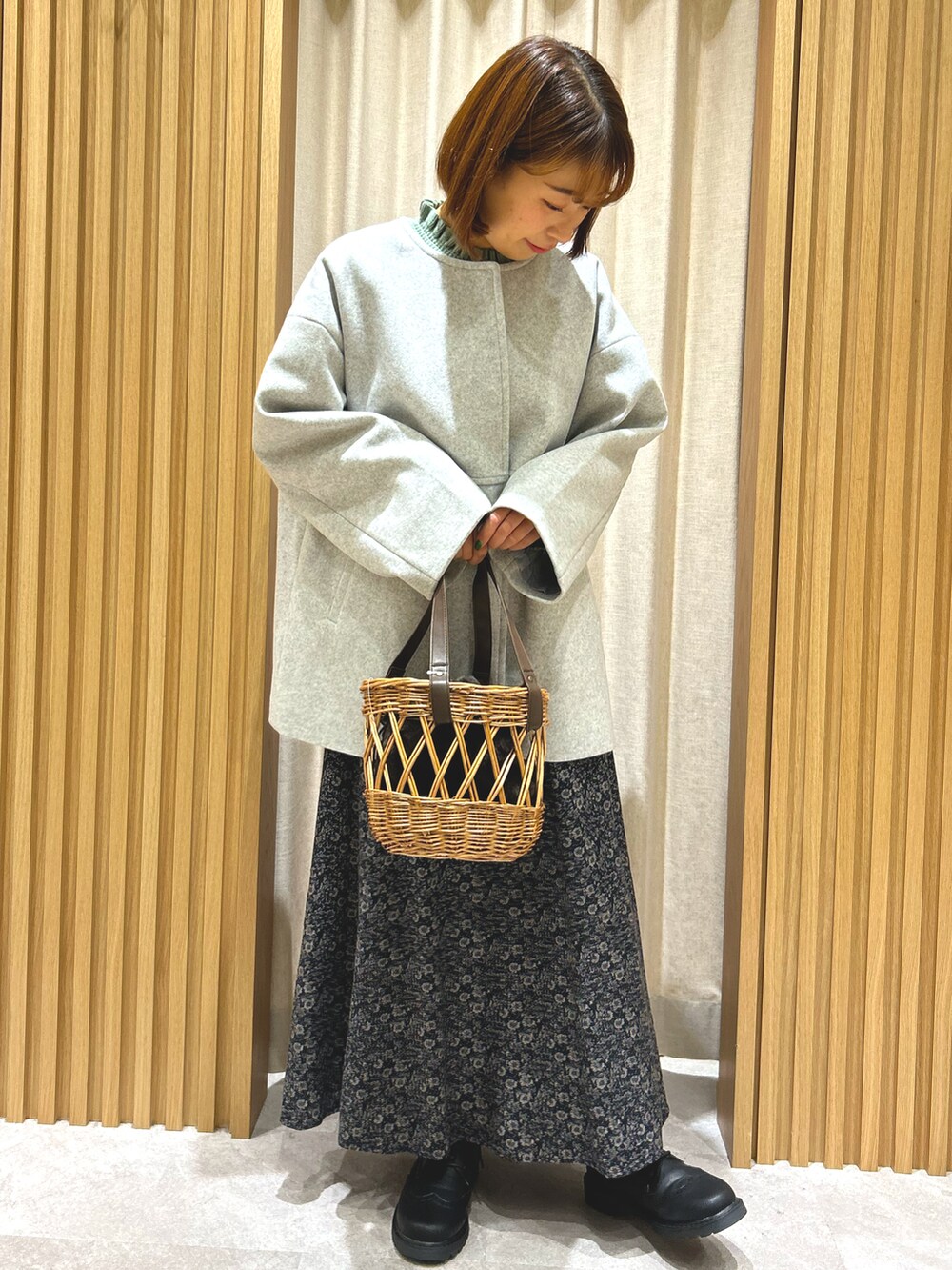 グリーン系のニット/セーター、グレー系のその他アウター、ブラック系のスカートを着用したレディースの秋コーディネートの2枚目の写真