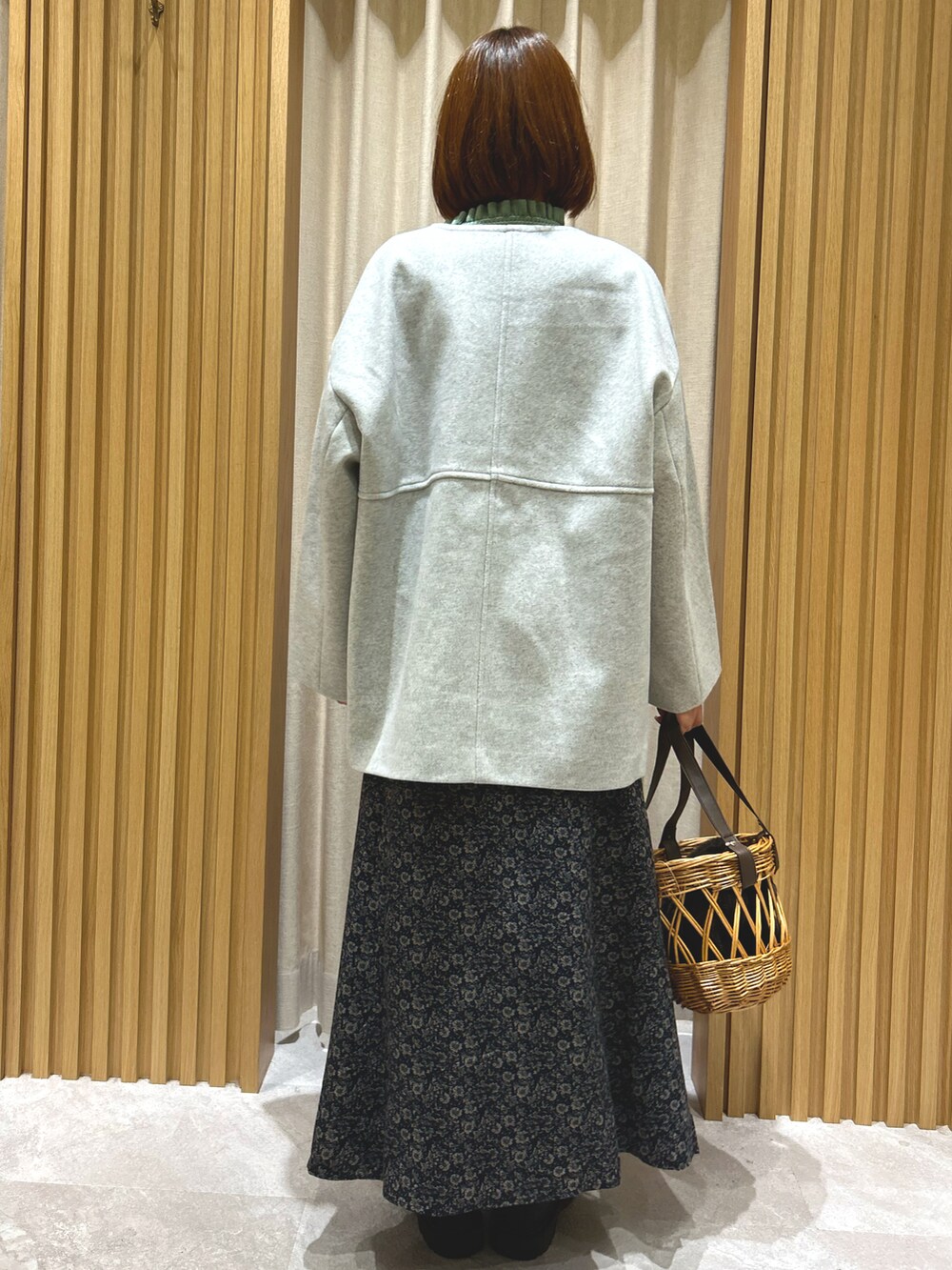 グリーン系のニット/セーター、グレー系のその他アウター、ブラック系のスカートを着用したレディースの秋コーディネートの4枚目の写真