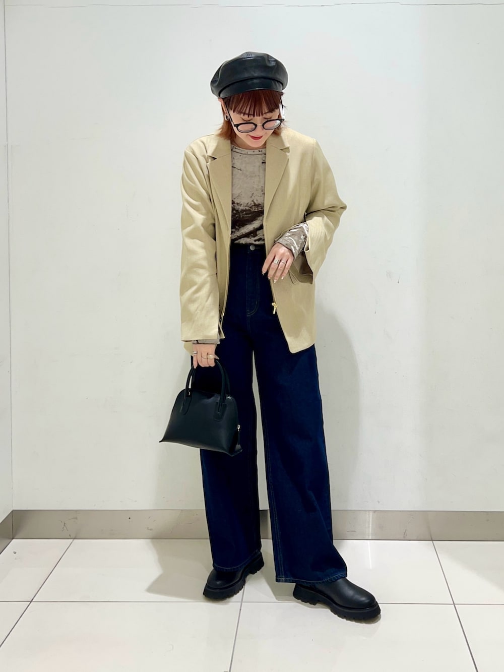 ブラック系のブーツ、ブルー系のデニムパンツ、ブラック系のショルダーバッグを着用したレディースの冬コーディネートの6枚目の写真