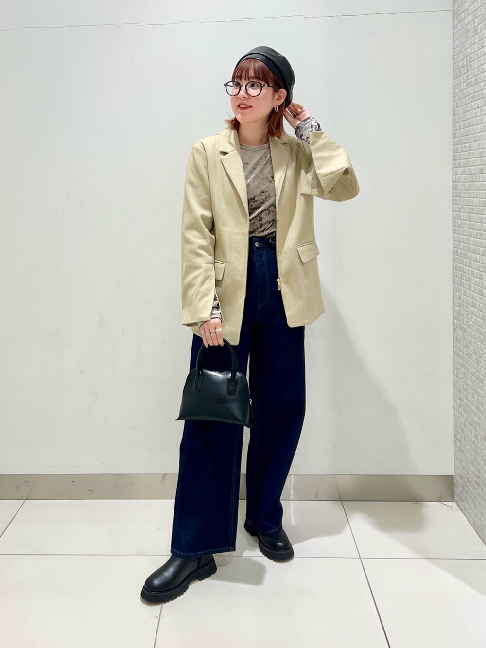 ブラック系のブーツ、ブルー系のデニムパンツ、ブラック系のショルダーバッグを着用したレディースの冬コーディネートの2枚目の写真