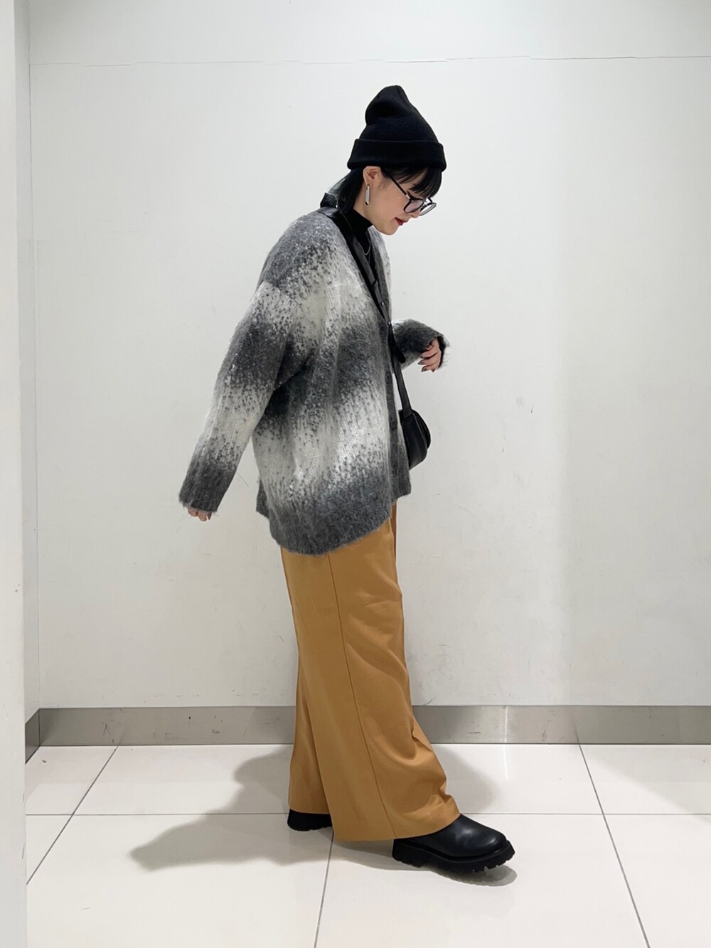 ブラック系のニット/セーター、ブラック系のショルダーバッグ、グレー系のカーディガン/ボレロを着用したレディースの秋コーディネートの5枚目の写真