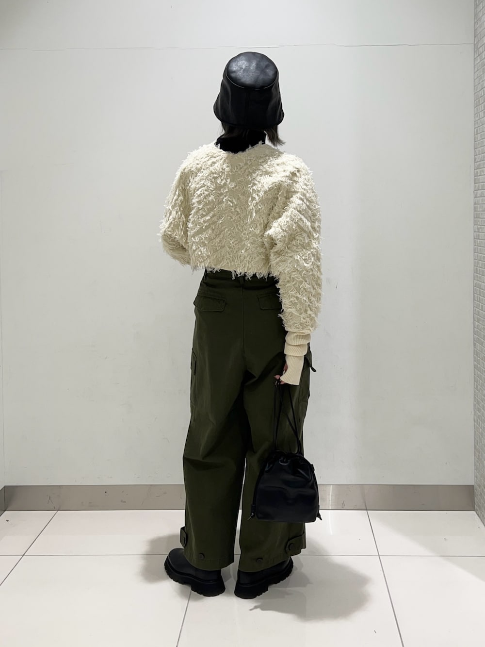 グリーン系のその他パンツ、ブラック系のショルダーバッグ、ブラック系のブーツを着用したレディースの秋コーディネートの4枚目の写真