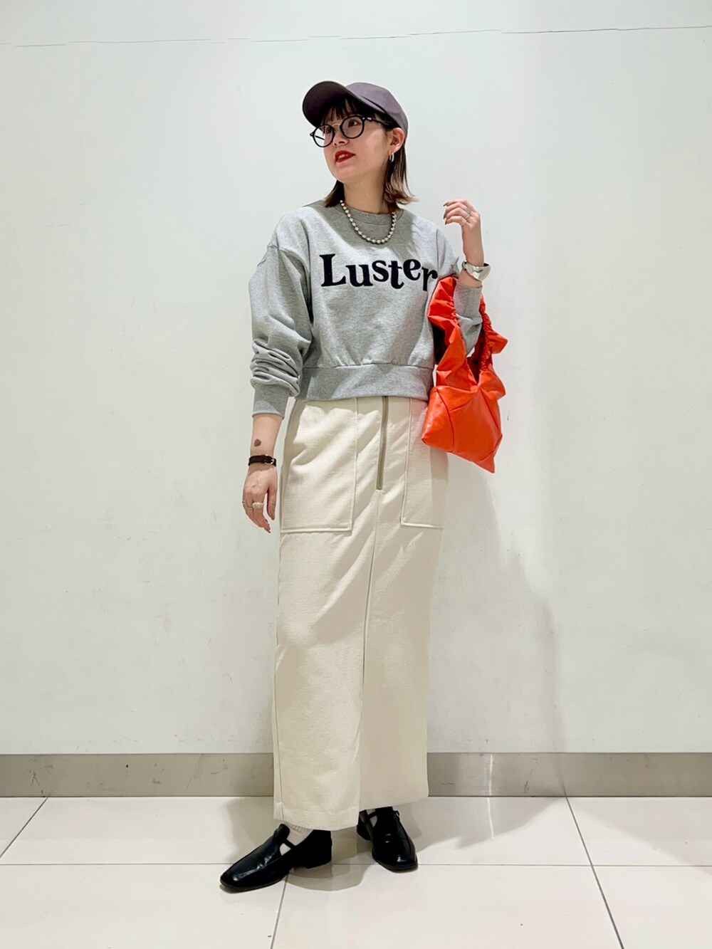 ブラック系のローファー、ホワイト系のスカート、その他のスウェットを着用したレディースの春コーディネートの2枚目の写真