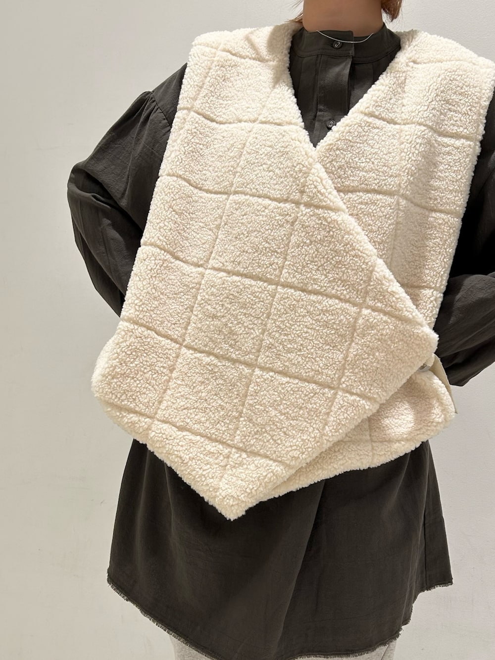 ホワイト系のベスト、グリーン系のワンピース、グレー系のその他パンツを着用したレディースの秋コーディネートの7枚目の写真