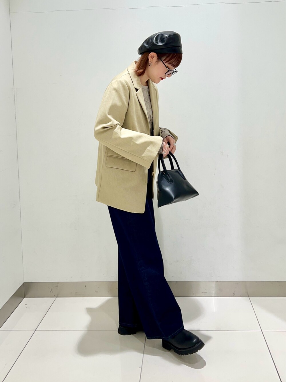 ブラック系のブーツ、ブルー系のデニムパンツ、ブラック系のショルダーバッグを着用したレディースの冬コーディネートの5枚目の写真