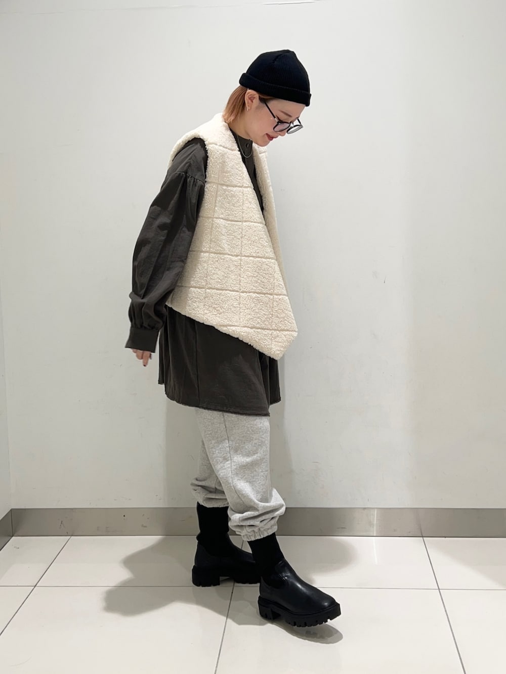 ホワイト系のベスト、グリーン系のワンピース、グレー系のその他パンツを着用したレディースの秋コーディネートの5枚目の写真