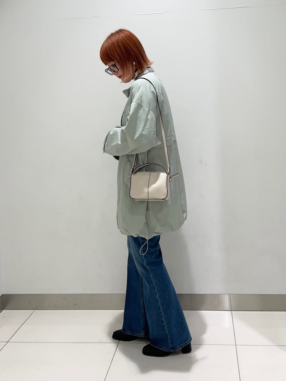 グリーン系のその他アウター、ホワイト系のニット/セーター、ブルー系のデニムパンツを着用したレディースの秋コーディネートの3枚目の写真