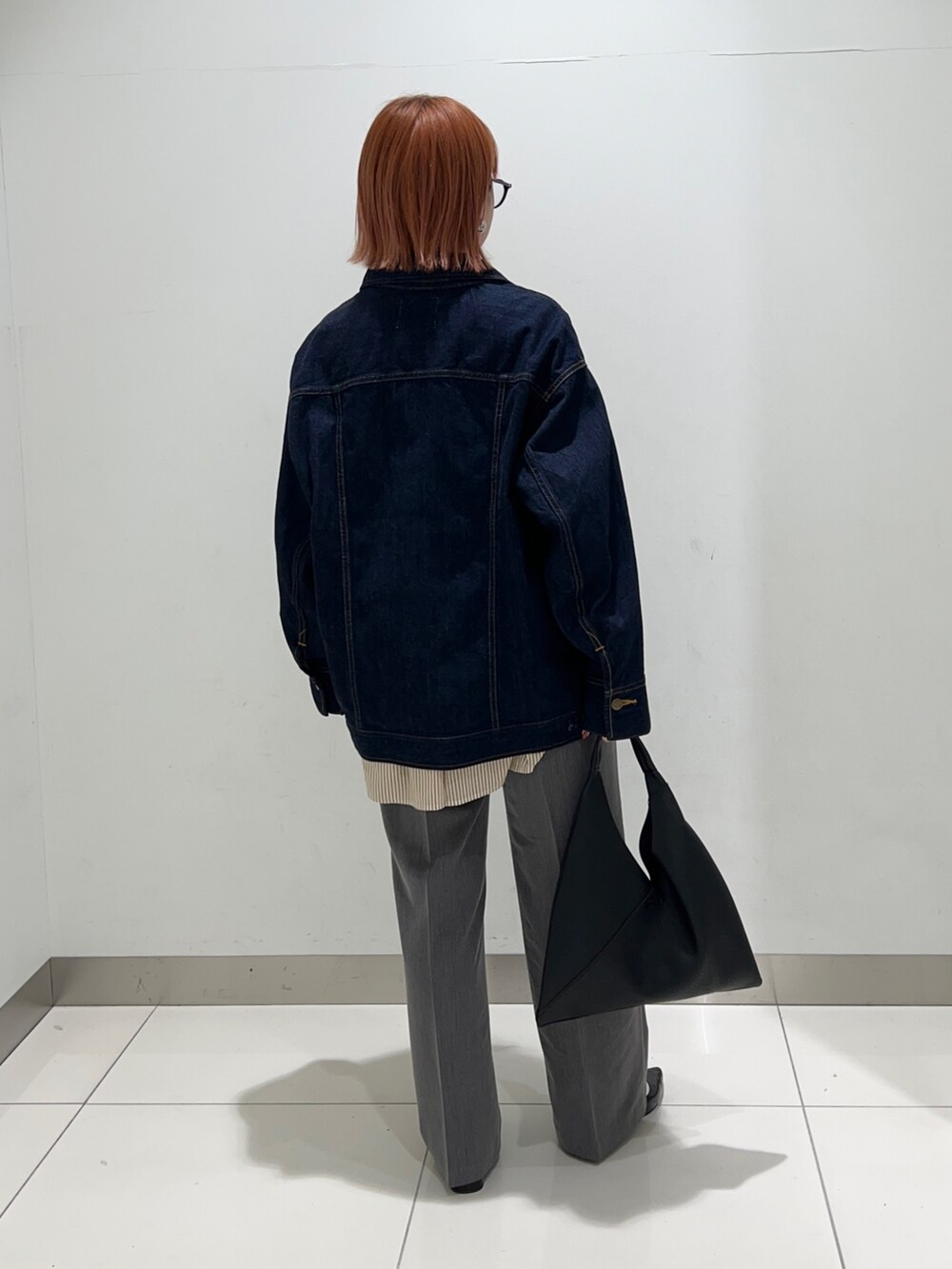 イエロー系のシャツ/ブラウス、ブルー系のデニムジャケット、グレー系のスラックスを着用したレディースの秋コーディネートの4枚目の写真