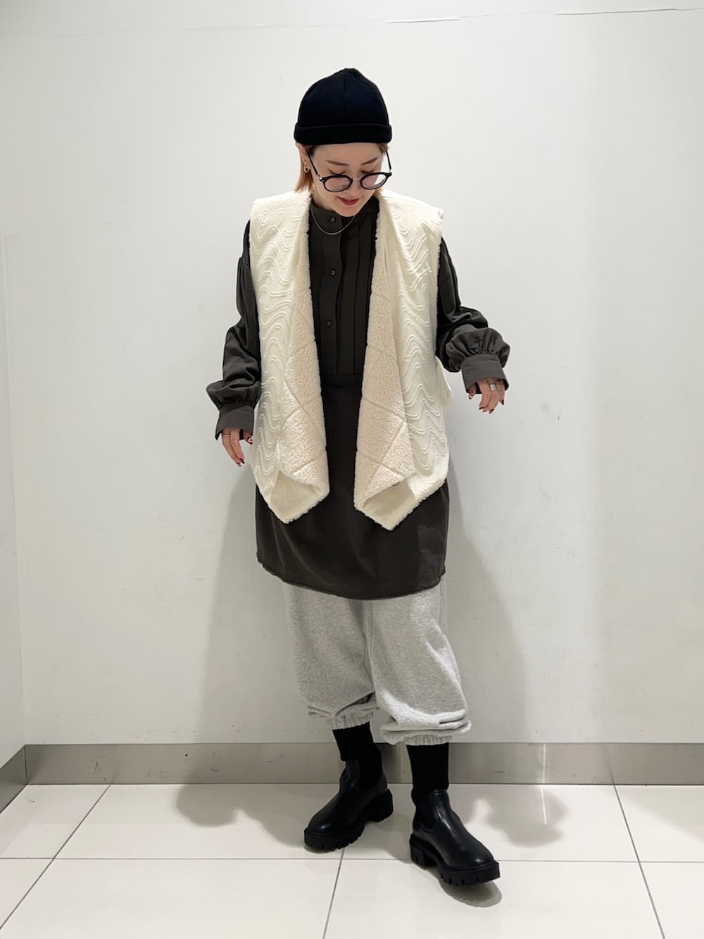 ホワイト系のベスト、グリーン系のワンピース、グレー系のその他パンツを着用したレディースの秋コーディネートの8枚目の写真