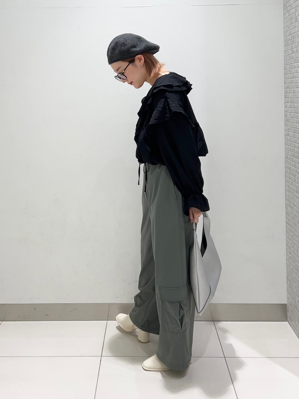 ブラック系のシャツ/ブラウス、グリーン系のサロペット/オーバーオール、ホワイト系のブーツを着用したレディースの秋コーディネートの3枚目の写真