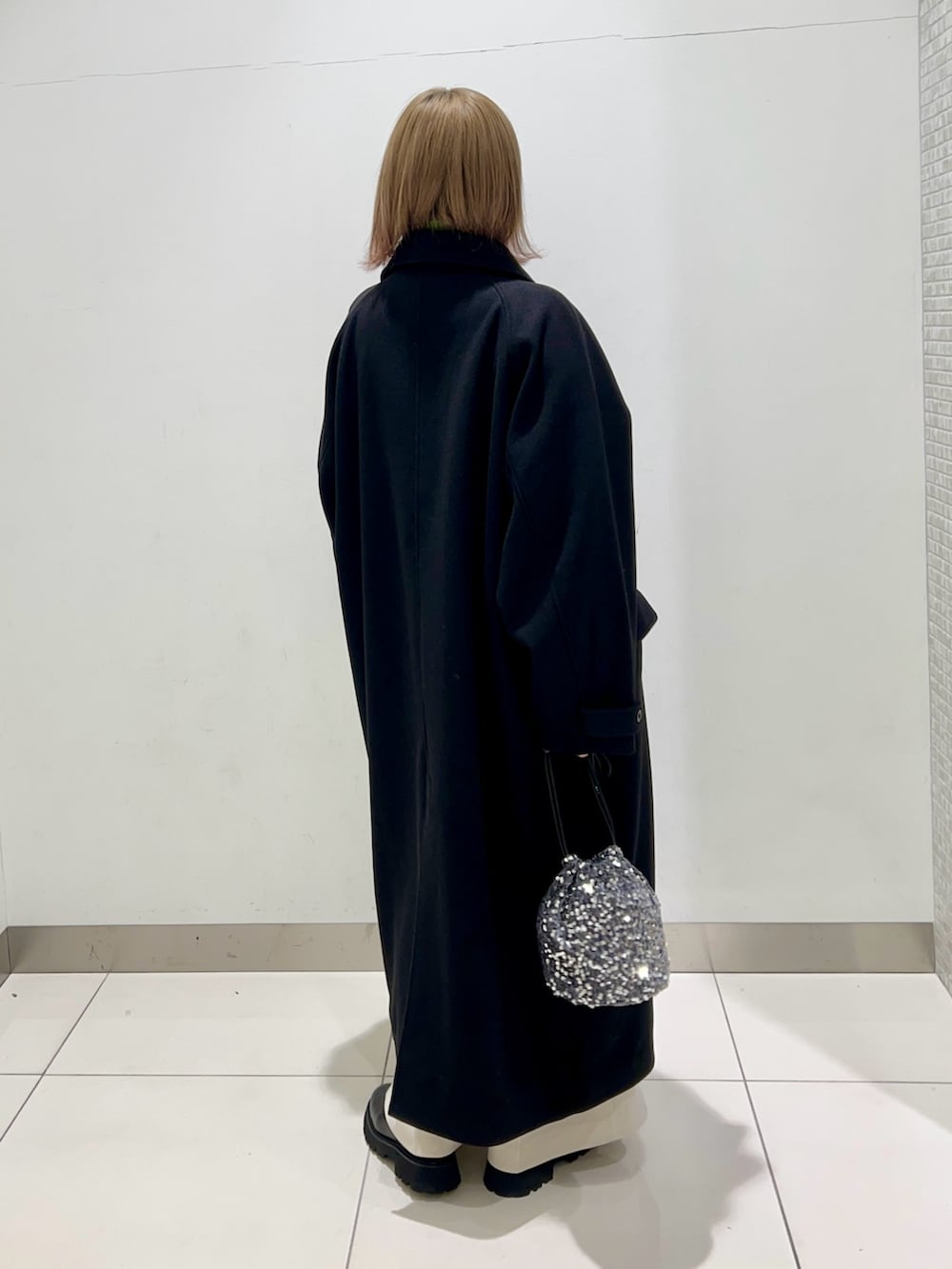 グリーン系のニット/セーター、ホワイト系のその他パンツ、ブラック系のブーツを着用したレディースの冬コーディネートの6枚目の写真