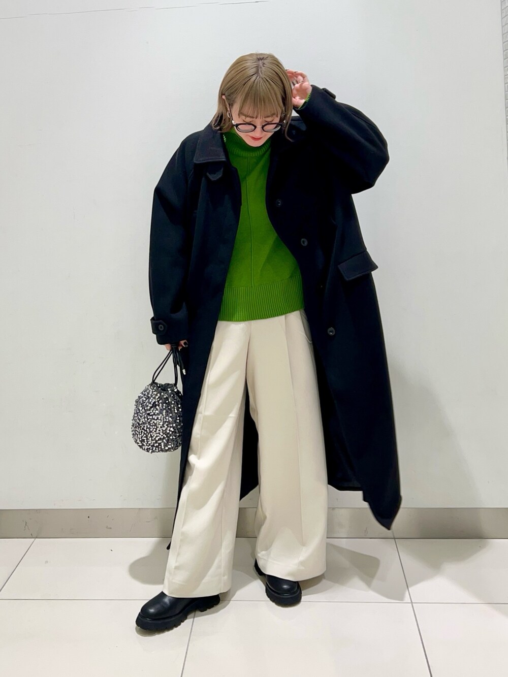 グリーン系のニット/セーター、ホワイト系のその他パンツ、ブラック系のブーツを着用したレディースの冬コーディネートの8枚目の写真