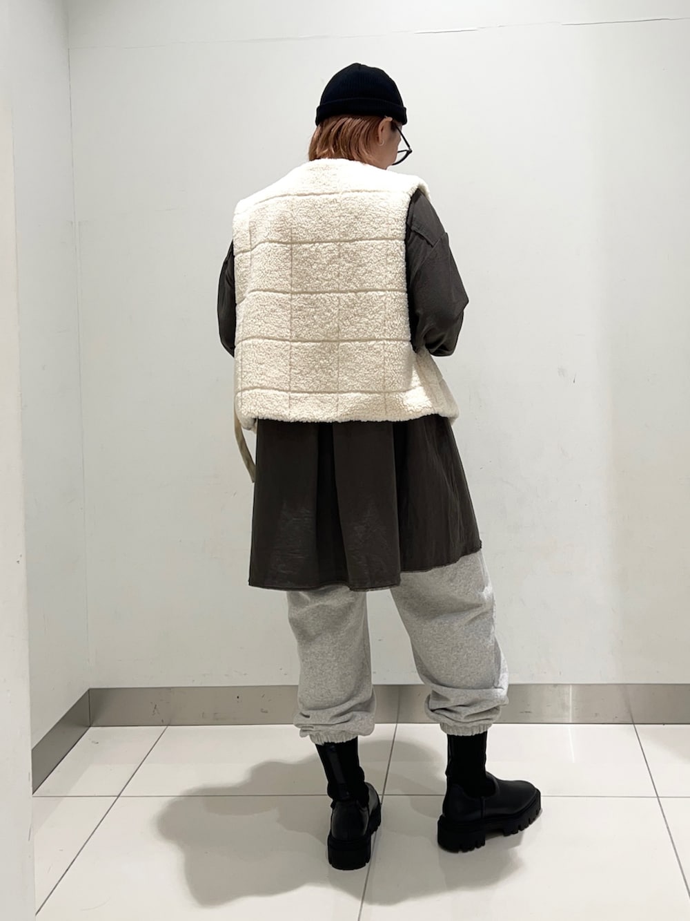 ホワイト系のベスト、グリーン系のワンピース、グレー系のその他パンツを着用したレディースの秋コーディネートの4枚目の写真