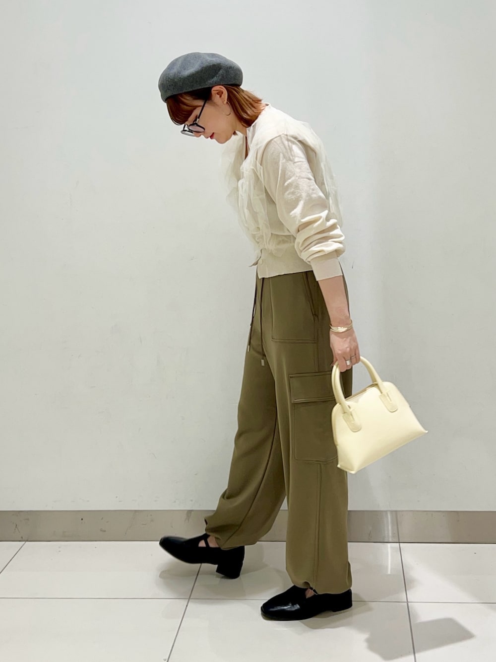 グリーン系のその他パンツ、イエロー系のショルダーバッグ、ブラック系のローファーを着用したレディースの冬コーディネートの3枚目の写真