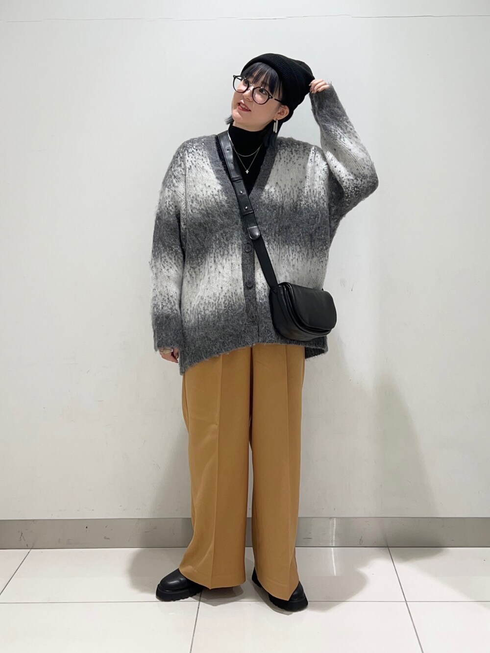 ブラック系のニット/セーター、ブラック系のショルダーバッグ、グレー系のカーディガン/ボレロを着用したレディースの秋コーディネートの7枚目の写真