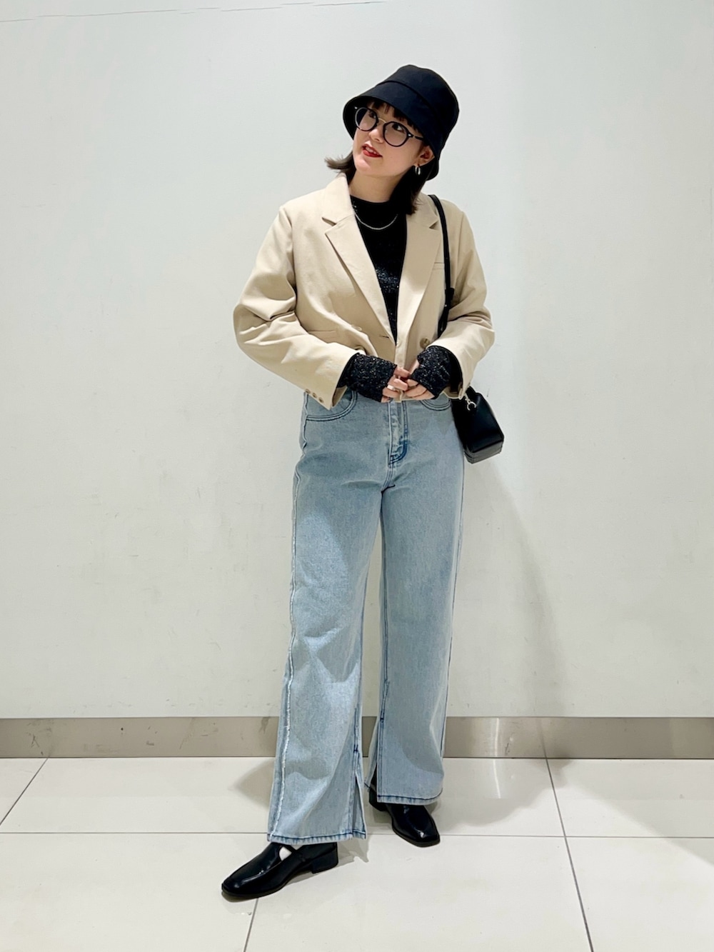 ブラック系のTシャツ/カットソー、ベージュ系のその他アウター、ブラック系のショルダーバッグを着用したレディースの春コーディネートの6枚目の写真