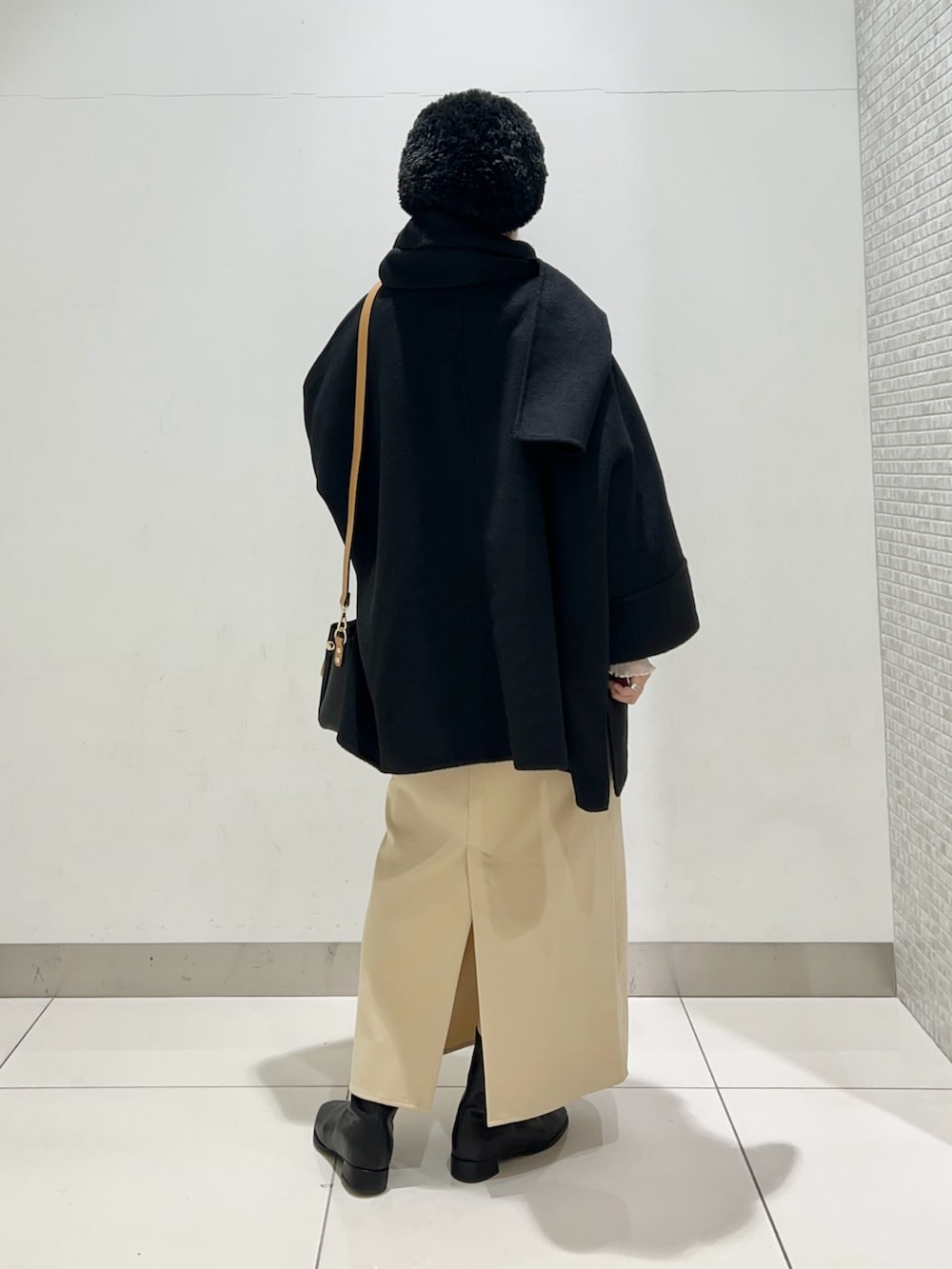 ブラック系のその他アウター、ブラック系のトートバッグ、ベージュ系のワンピースを着用したレディースの冬コーディネートの4枚目の写真