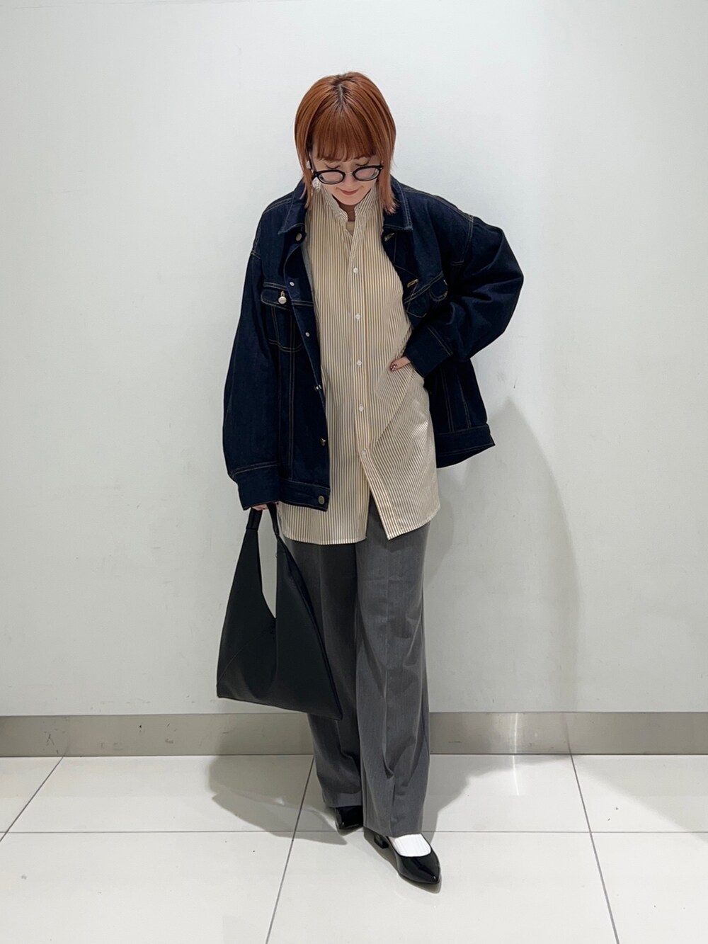 イエロー系のシャツ/ブラウス、ブルー系のデニムジャケット、グレー系のスラックスを着用したレディースの秋コーディネートの6枚目の写真