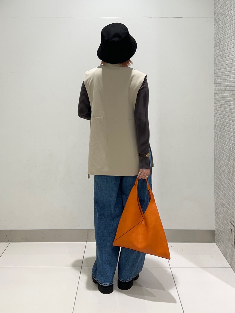 ベージュ系のジャケット/アウター、グレー系のニット/セーター、ブラック系のブーツを着用したレディースの秋コーディネートの4枚目の写真
