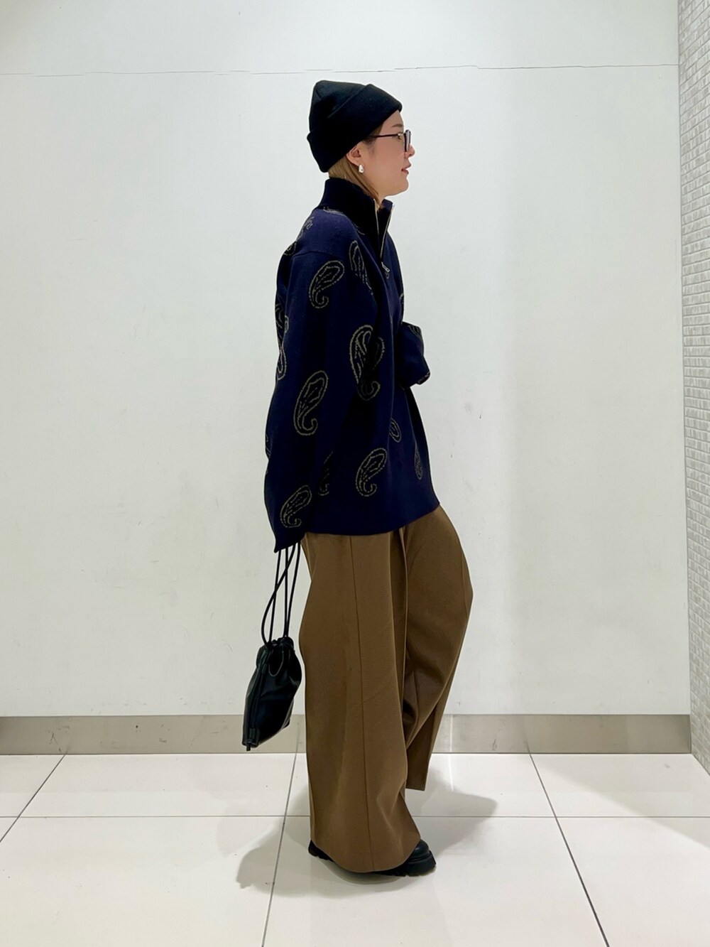 ブルー系のニット/セーター、ブラック系のショルダーバッグ、ベージュ系のその他パンツを着用したレディースの冬コーディネートの5枚目の写真