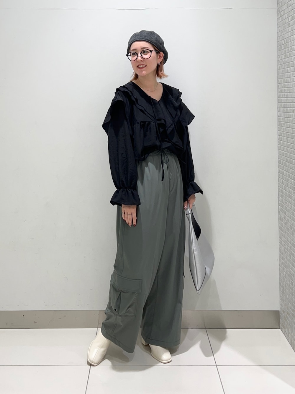 ブラック系のシャツ/ブラウス、グリーン系のサロペット/オーバーオール、ホワイト系のブーツを着用したレディースの秋コーディネートの7枚目の写真