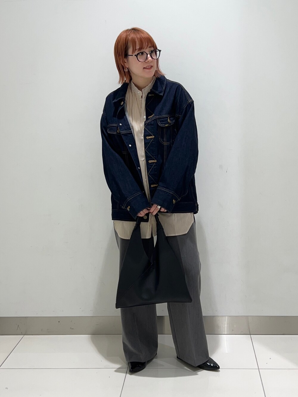 イエロー系のシャツ/ブラウス、ブルー系のデニムジャケット、グレー系のスラックスを着用したレディースの秋コーディネートの2枚目の写真