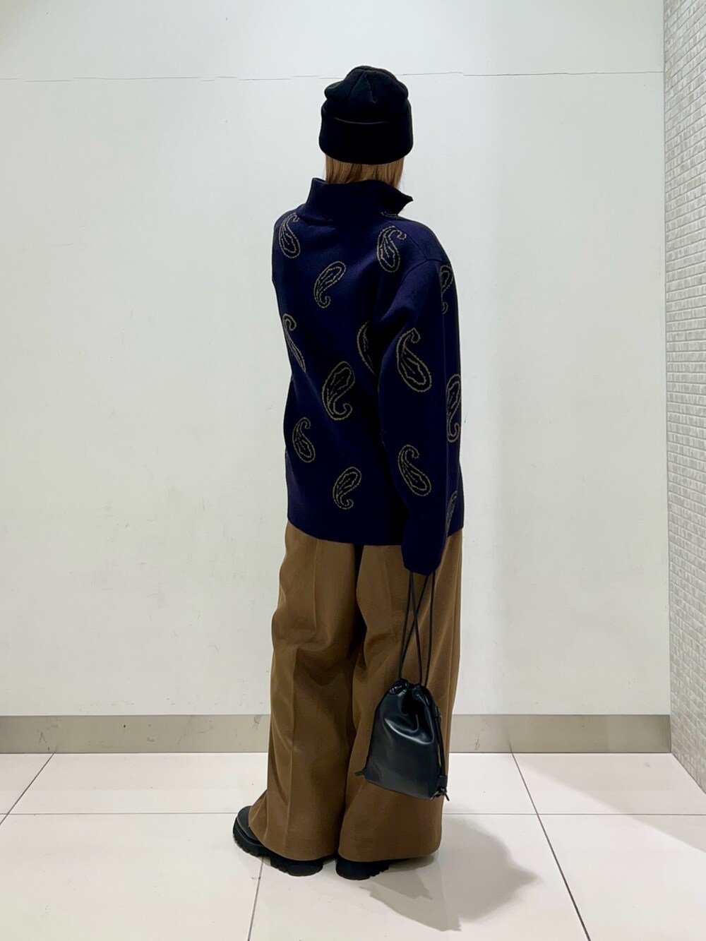 ブルー系のニット/セーター、ブラック系のショルダーバッグ、ベージュ系のその他パンツを着用したレディースの冬コーディネートの4枚目の写真