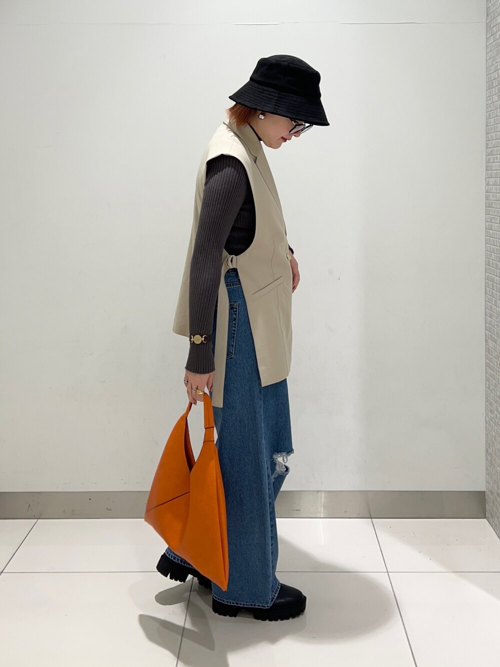 ベージュ系のジャケット/アウター、グレー系のニット/セーター、ブラック系のブーツを着用したレディースの秋コーディネートの5枚目の写真