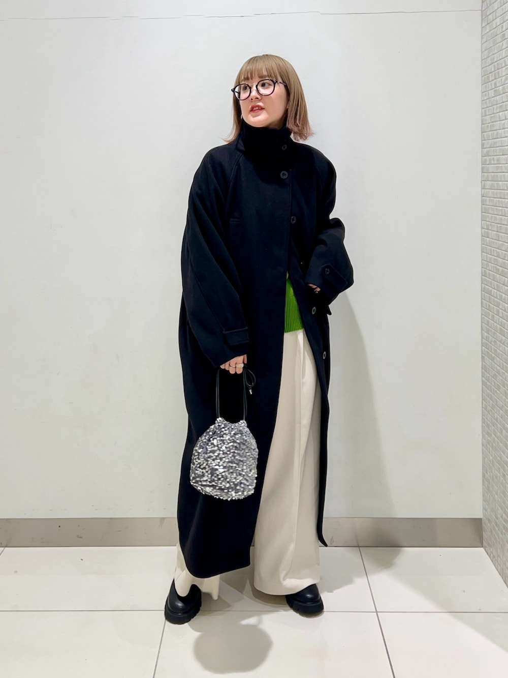 グリーン系のニット/セーター、ホワイト系のその他パンツ、ブラック系のブーツを着用したレディースの冬コーディネートの9枚目の写真