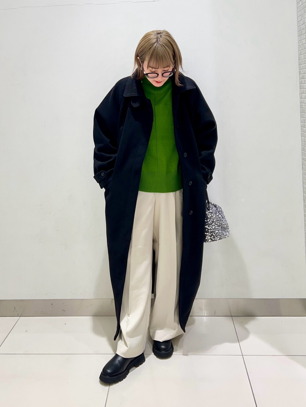 グリーン系のニット/セーター、ホワイト系のその他パンツ、ブラック系のブーツを着用したレディースの冬コーディネートの4枚目の写真