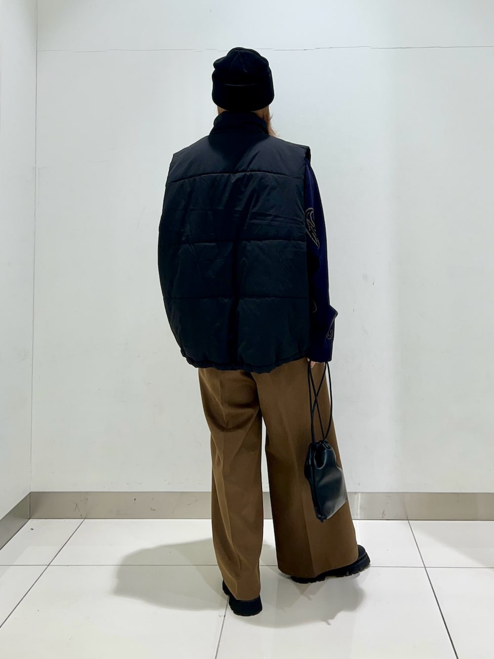 ブルー系のニット/セーター、ブラック系のショルダーバッグ、ベージュ系のその他パンツを着用したレディースの冬コーディネートの8枚目の写真