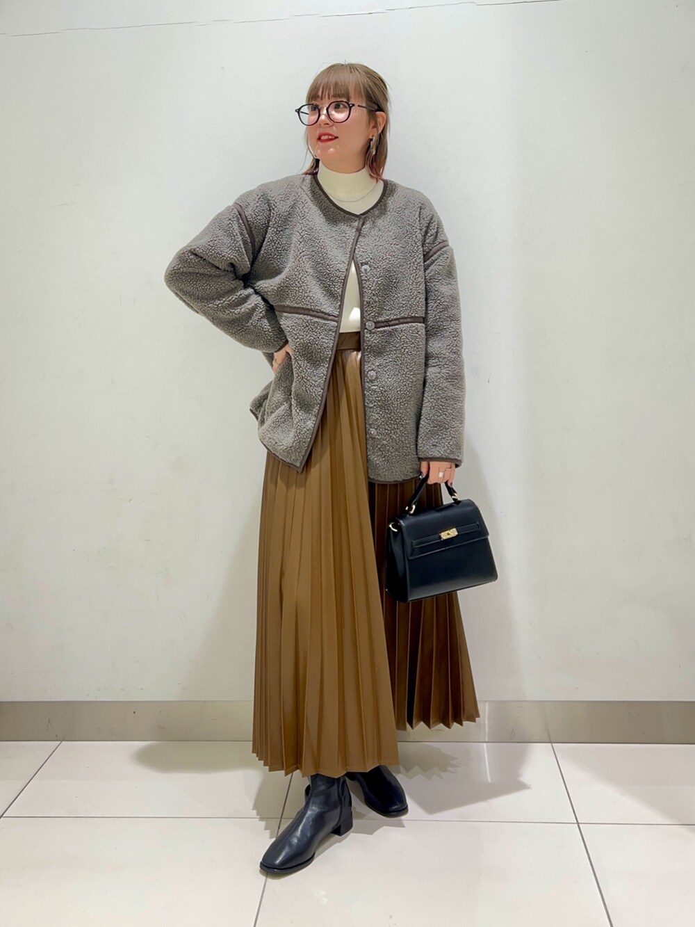 ブラック系のブーツ、ブラウン系のスカート、グレー系のその他アウターを着用したレディースの秋コーディネートの7枚目の写真